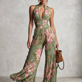 Peto de gasa verde con estampado floral, escote en V, sin mangas, con cremallera y pernera ancha, con pliegues.